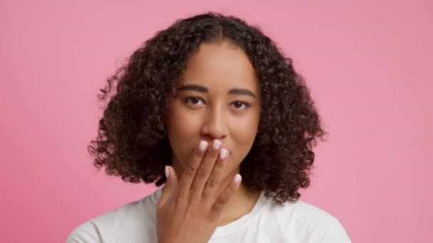 Afro-americana mujer soplando un beso sobre rosa estudio fondo — Vídeos de Stock