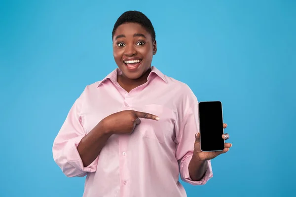 Fekete nő megjelenítése telefon képernyőn, mutató ujj a kék háttér — Stock Fotó