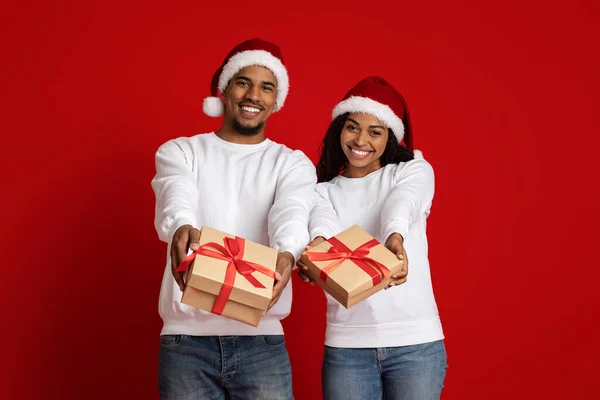 Noel Baba şapkalı, hediye kutularıyla Afrikalı Amerikalı çifte bayılıyorlar. — Stok fotoğraf