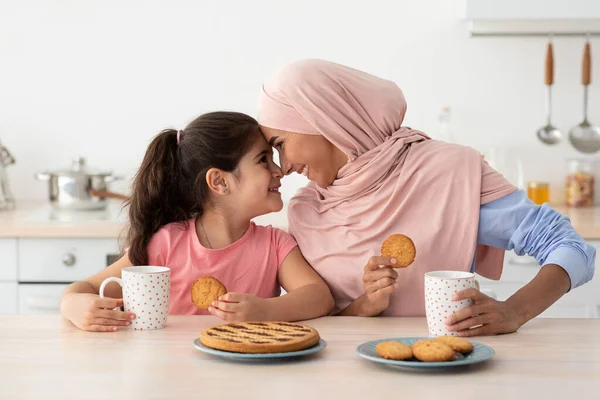 Mutfakta abur cubur yerken İslami anne ve kızı kaynaştırmak — Stok fotoğraf
