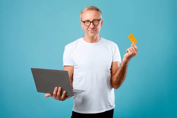 Izgalmas érett férfi kezében hitelkártya és laptop — Stock Fotó