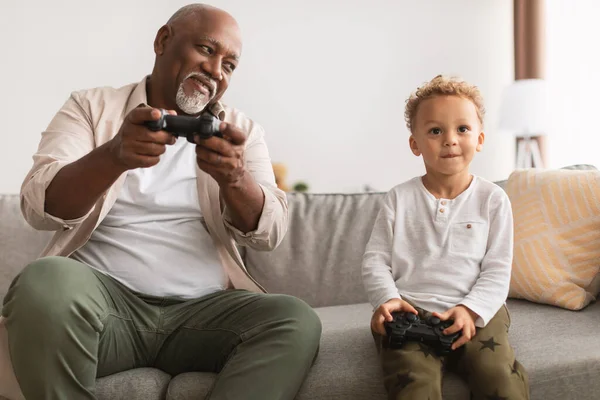 Preto avô e neto jogar videogames se divertindo em casa — Fotografia de Stock