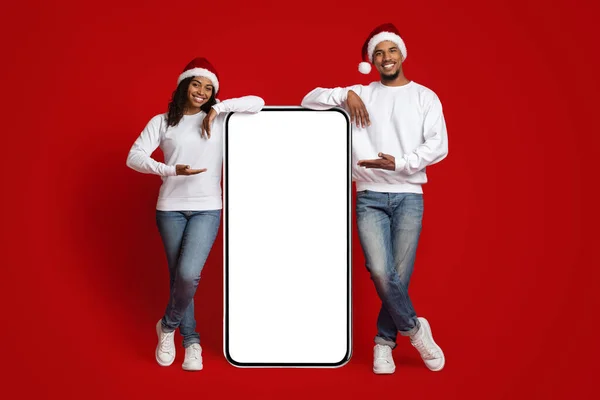 Positieve Afrikaanse amerikaanse minnaars tonen enorme mobiele telefoon met lege display — Stockfoto