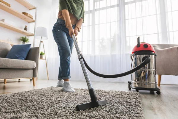 Primer plano de la mujer musulmana alfombra alfombra de limpieza con aspiradora — Foto de Stock