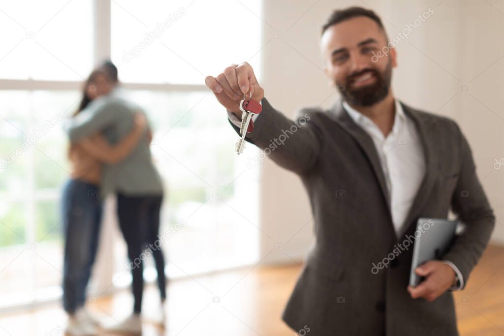 Smiling Real Estate Agent Holding And Showing Key