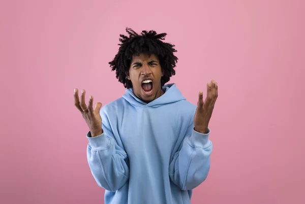 Furioso adolescente negro gritando de raiva no fundo do estúdio rosa — Fotografia de Stock