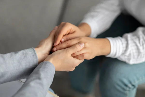 Psychologische ondersteuning. Psychotherapeut biedt hulp aan jonge vrouw, houdt haar handen vast tijdens psychotherapie sessie — Stockfoto