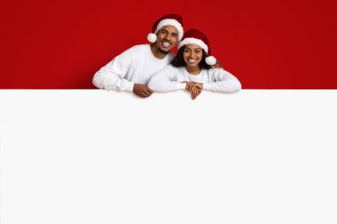 Sevimli siyah çift yatay reklam panosuyla poz veriyor.