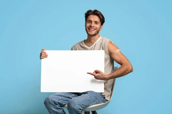 Anuncio de vacunación. Joven Vacunado Señalando Placard en Blanco En Sus Manos —  Fotos de Stock