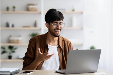 Orta Doğulu karizmatik bir adam iş arkadaşlarıyla görüntülü görüşme yapıyor.