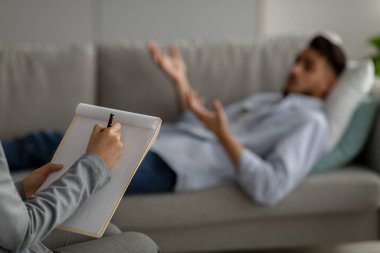 Psikolojik travma. Depresyondaki Arap adamla çalışan psikolog, kanepede yatan orta doğulu erkek hasta.