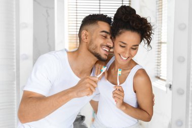 Tuvalette diş fırçalarken genç ve romantik Arap Çiftin Portresi