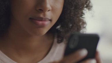 Modern aletler ve sanal dünya. Tanımlanamayan siyah kadın web sörfünün bulanık akıllı telefondaki portresini kapat