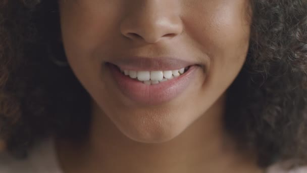 Diş sağlığı ve stomatoloji konsepti. Tanımlanamayan Afrikalı Amerikalı kadın kameraya gülümsüyor, beyaz gülüyor. — Stok video