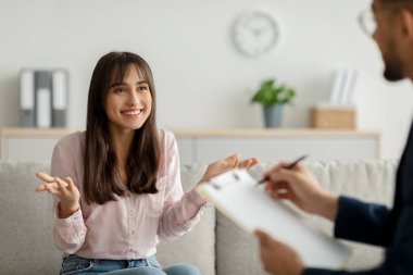 Etkili psikoterapi. Mutlu Arap kadın psikoloğuyla konuşuyor, klinikten profesyonel yardım alıyor.