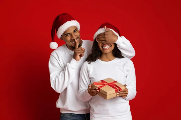 Hombre negro cariñoso dando regalo de Navidad a su novia, cubriendo los ojos — Foto de Stock