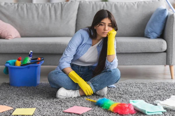 Mulher perturbada cansado de limpeza sentado no tapete tapete — Fotografia de Stock