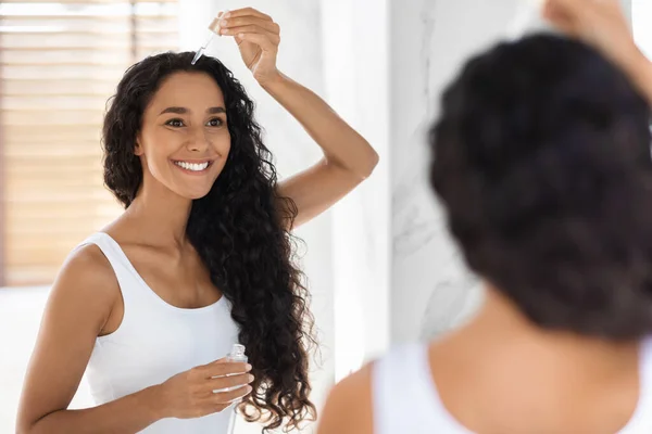 Conceito de cuidados com a pele. Mulher jovem bonita aplicando soro facial com conta-gotas no banheiro — Fotografia de Stock