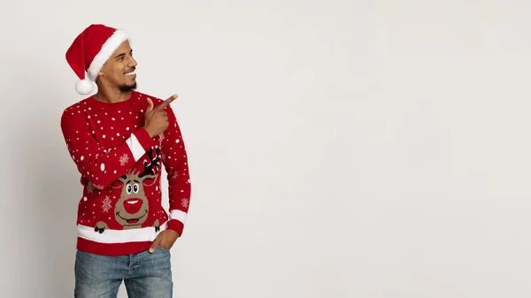 Snygg svart man i Santa hatt pekar på kopia utrymme — Stockfoto