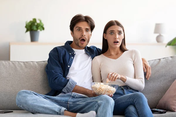 Έκπληκτο φοβισμένο νεαρό ευρωπαϊκό ζευγάρι με ανοιχτά στόματα που τρώει ποπ κορν και βλέπει ταινία — Φωτογραφία Αρχείου