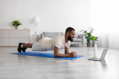 İyi ki genç siyah sakallı bir adam döşeme döşeme döşemesi yapıyor oda içinde bir şişe suyla, dikkat et.