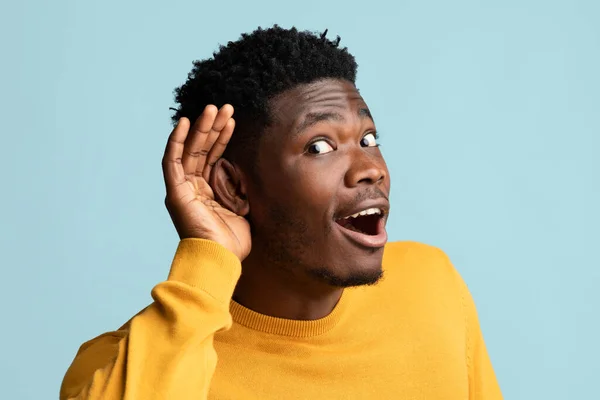 Nieuwsgierige zwarte man die palm in oor houdt — Stockfoto