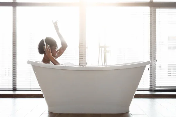 즐거운 흑인 여인 목욕을 하고 음악을 듣는 모습 — 스톡 사진