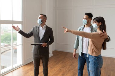 Tıbbi Maske Giyen Erkek Emlakçı Yeni Apartman Gösteriyor