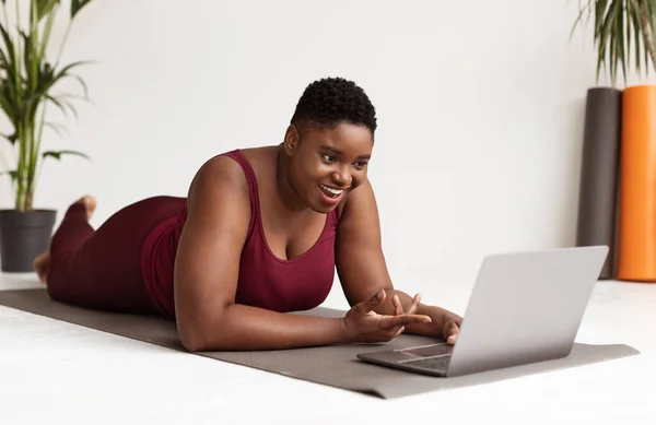 Šťastný baculatý černošky dáma s video chat s fitness trenér — Stock fotografie