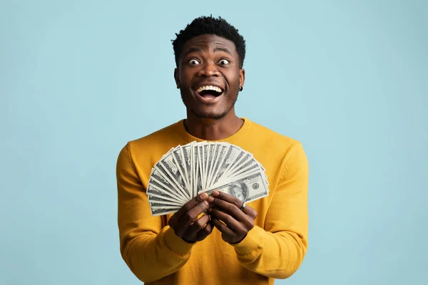 Lucky african american guy holding bunch of money