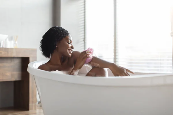 Ontspannen Afrikaans amerikaanse jonge vrouw nemen bad, zijaanzicht — Stockfoto
