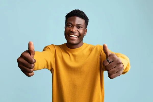 Radostný africký Američan ukazující palec nahoru na modré — Stock fotografie