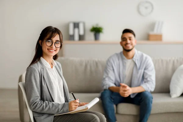 Successful treatment concept. Confident arab female psychologist and young man smiling after effective therapy — Stock Photo, Image