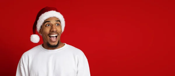 Verbazingwekkende zwarte man in Santa hoed op zoek naar kopieerruimte — Stockfoto