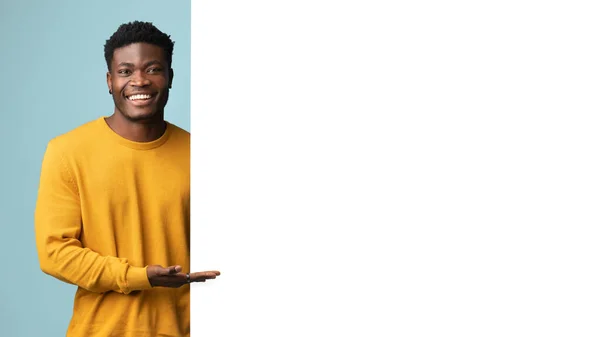 Usmívající se africký americký muž stojící u obrovské prázdné reklamní tabule — Stock fotografie