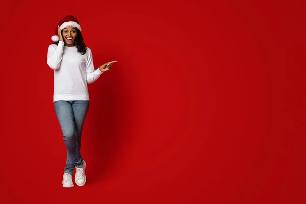 Afrikansk amerikansk kvinna i Santa hatt pekar på kopia utrymme — Stockfoto