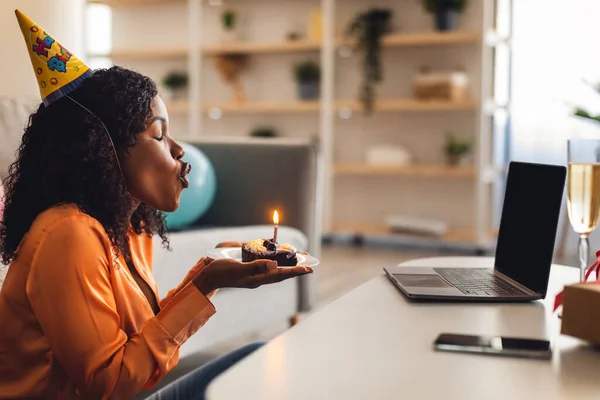 Laptop Üfleme Mumundaki Afrikalı Kadın. Kapalı alanda doğum günü pastası. — Stok fotoğraf