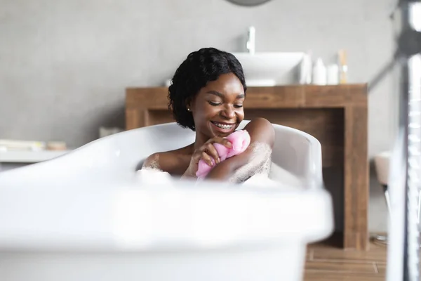 Gelukkig jong zwart dame die schuimig bad, scrubben huid — Stockfoto