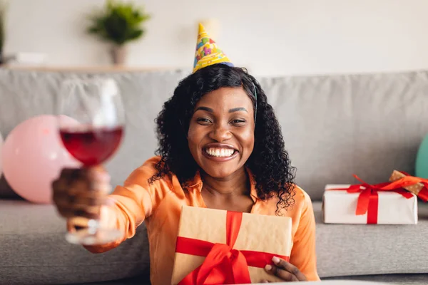 Zwarte vrouw vieren verjaardag toasten op camera Holding Gift Indoor — Stockfoto