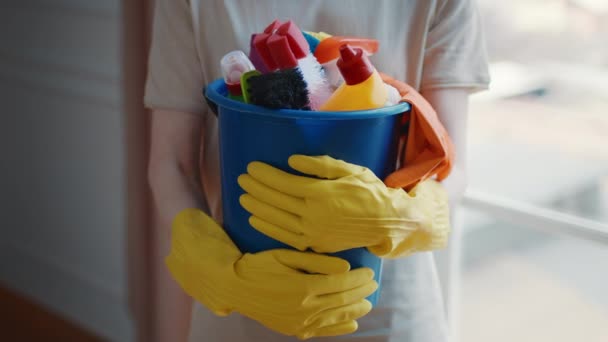 Cubo de retención de mujer irreconocible con detergentes y productos para el hogar en interiores — Vídeos de Stock