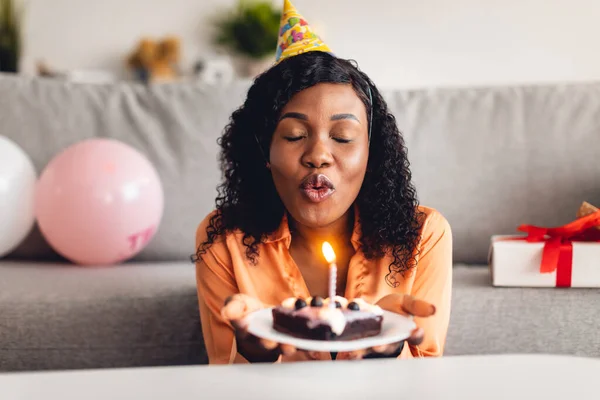 非洲妇女生日愿望在蛋糕室内吹响蜡烛 — 图库照片