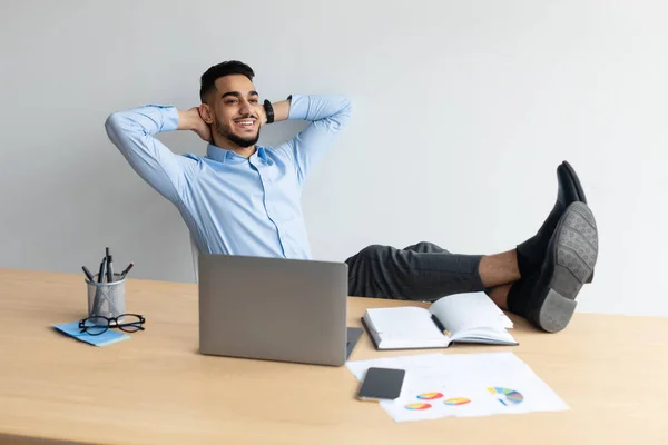 Sorridente uomo arabo appoggiato alla scrivania — Foto Stock