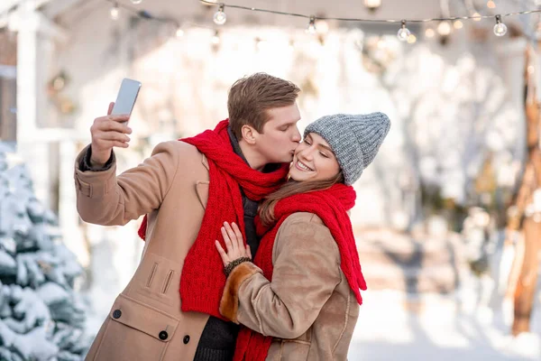 Romantic couple enjoying beautiful winter day, taking selfie — Stock Photo, Image