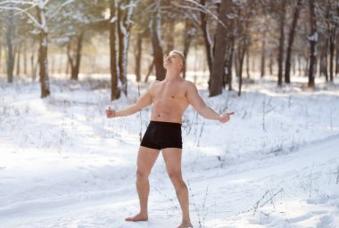 Strong senior man exposing himself to cold weather, standing in underwear at snowy park, full length clipart