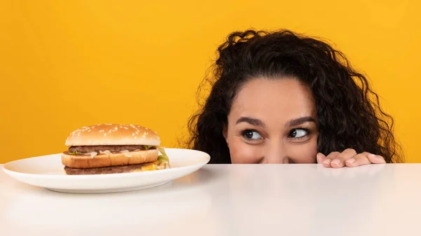 Hungry Lady Looking At Burger Peeping Out Table