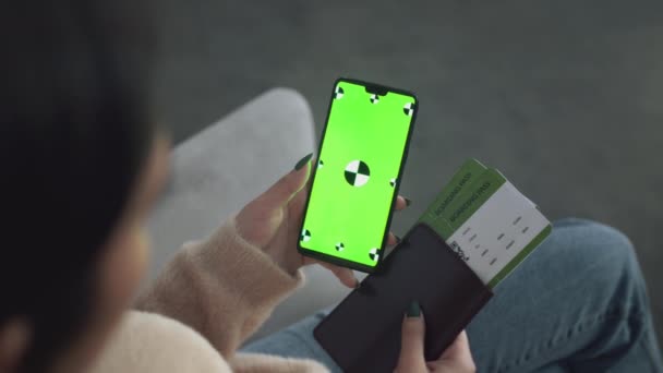 Неузнаваемая женщина с билетами на самолет делает онлайн-регистрацию на мобильное приложение, сотовый телефон с зеленым экраном хромы — стоковое видео