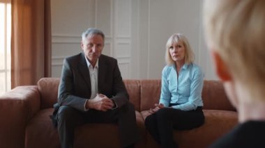 Ciddi kıdemli çift ofiste oturan profesyonel psikologu dinliyor.