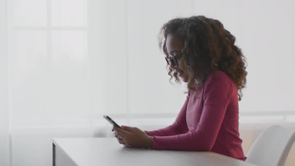 Niños y problemas de vista. Retrato de vista lateral de la niña afroamericana en gafas web surf en smartphone — Vídeos de Stock