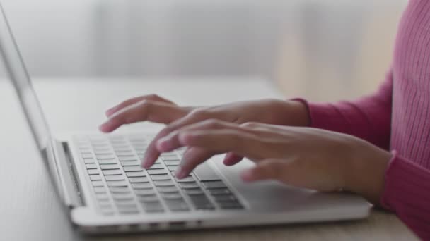 Chica negra irreconocible escribiendo en el ordenador portátil, aprendiendo a distancia en casa, haciendo tareas en casa, de cerca tiro de manos, zoom en — Vídeos de Stock