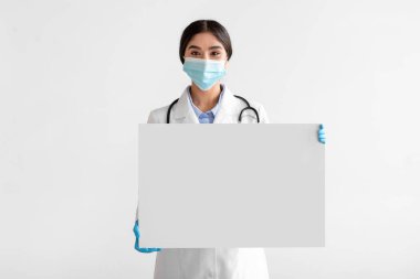 Beyaz önlüklü, koruyucu maske takan güzel Hintli doktor bayana sevindim.